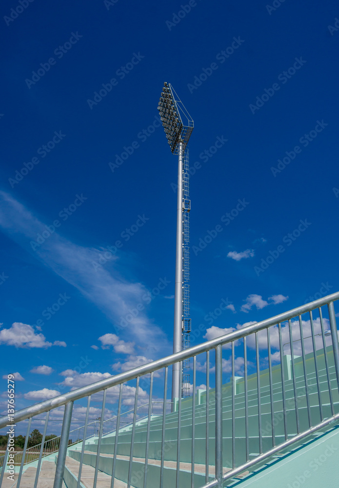 high pole Spotlight Stadium lights with blue sky background.