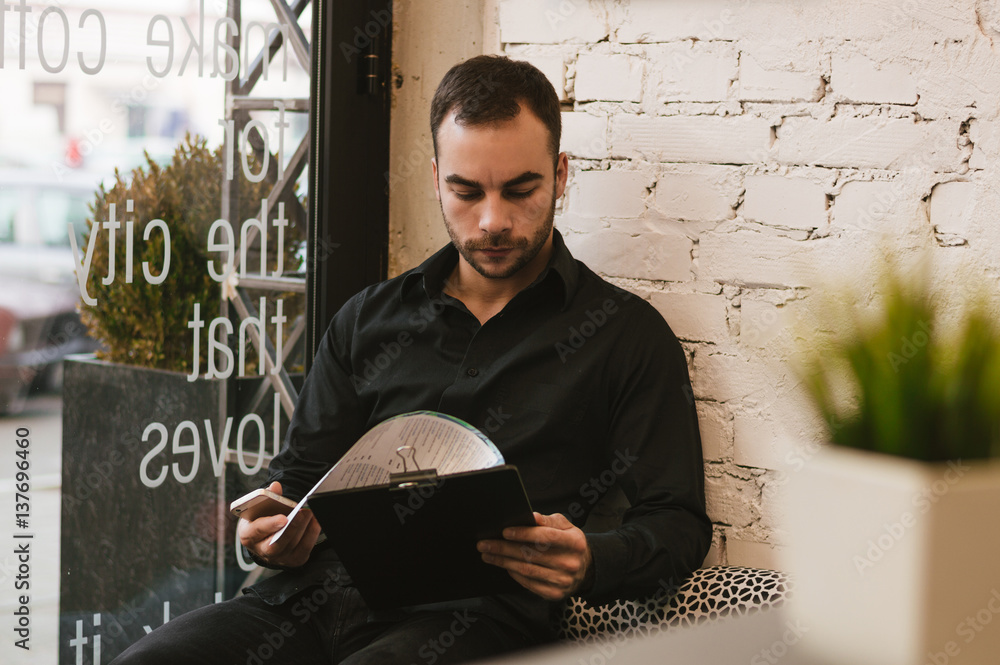 Handsome man at cafe checking menu.