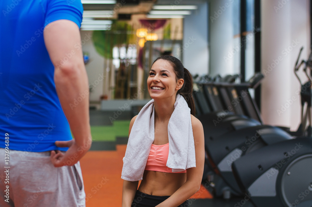 Pretty girl having a consultation with her personal trainer at the gym