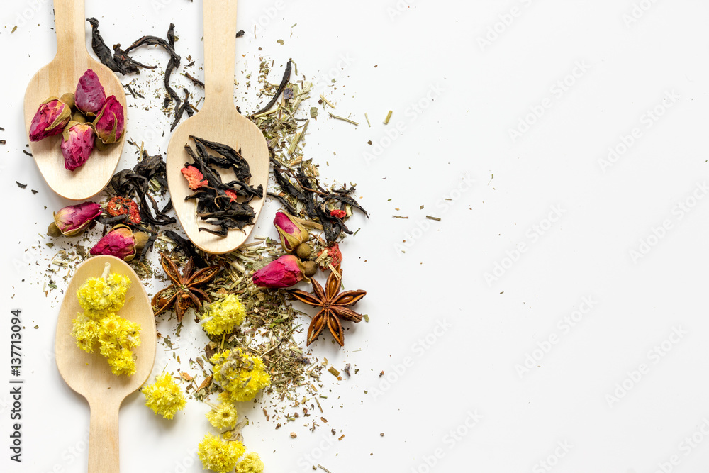 Virious herbs in wooden spoons on white table top view mockup