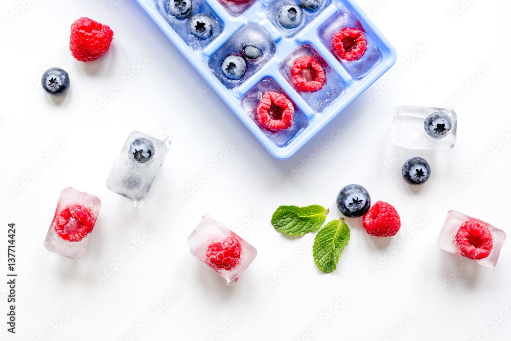 tray with berries ice cubes on white background top view