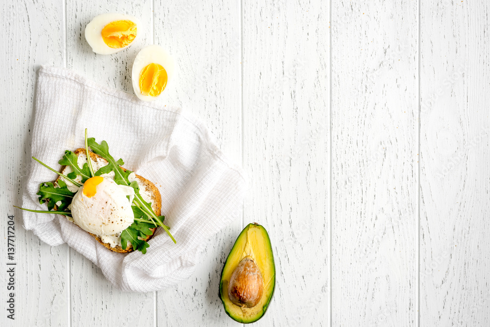 sandwich with poached eggs on wooden background top view mockup