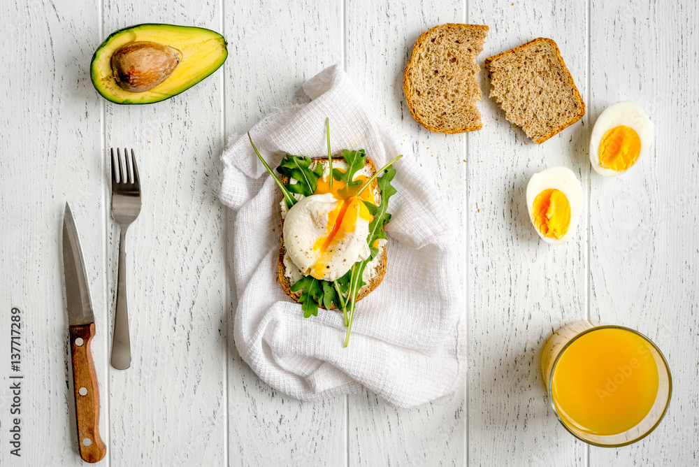 sandwich with poached eggs on wooden background top view