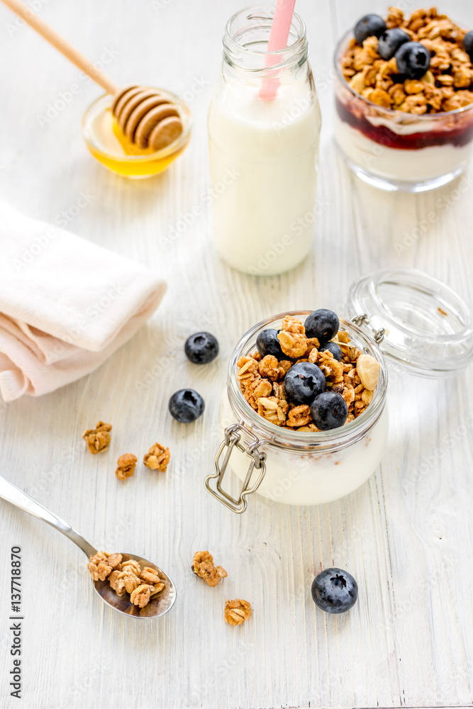 Fitness breakfast with granola, milk and honey on white background