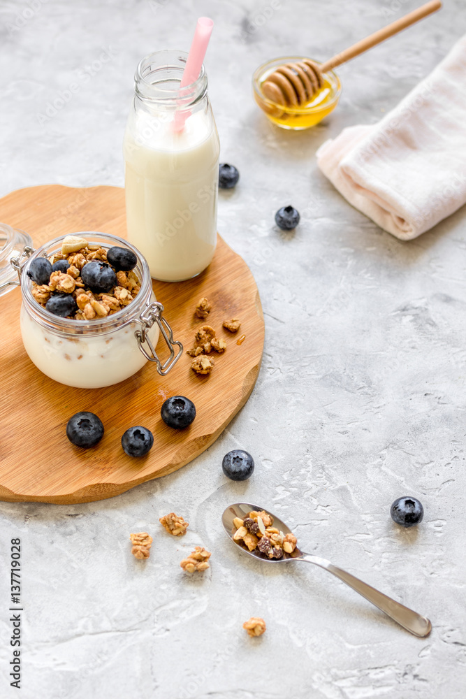 Morning granola with yogurt, honey and berries on white table