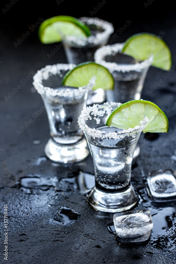 Alcohol party with tequila, ice and salt on black background