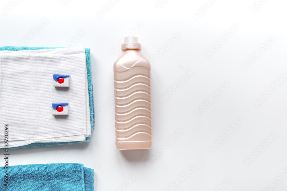 Towels pile with detergent and plastic bottles in laundry top view mockup