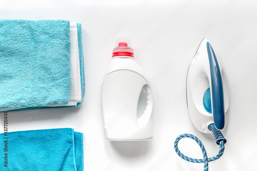 Launry set with towels and iron on white background top view