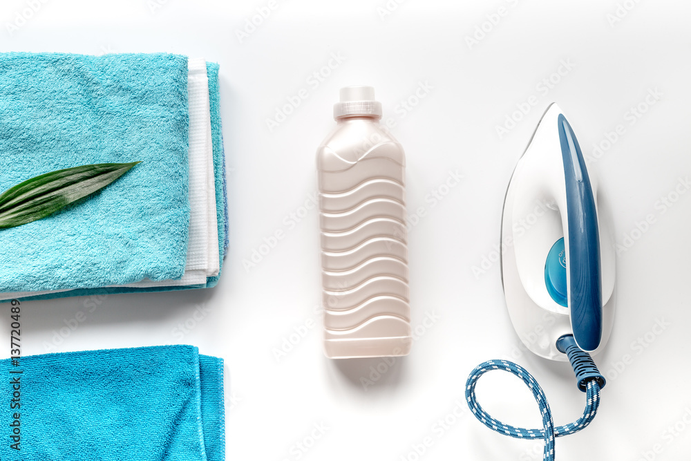 housekeeping set with towels and iron on laundry background top view