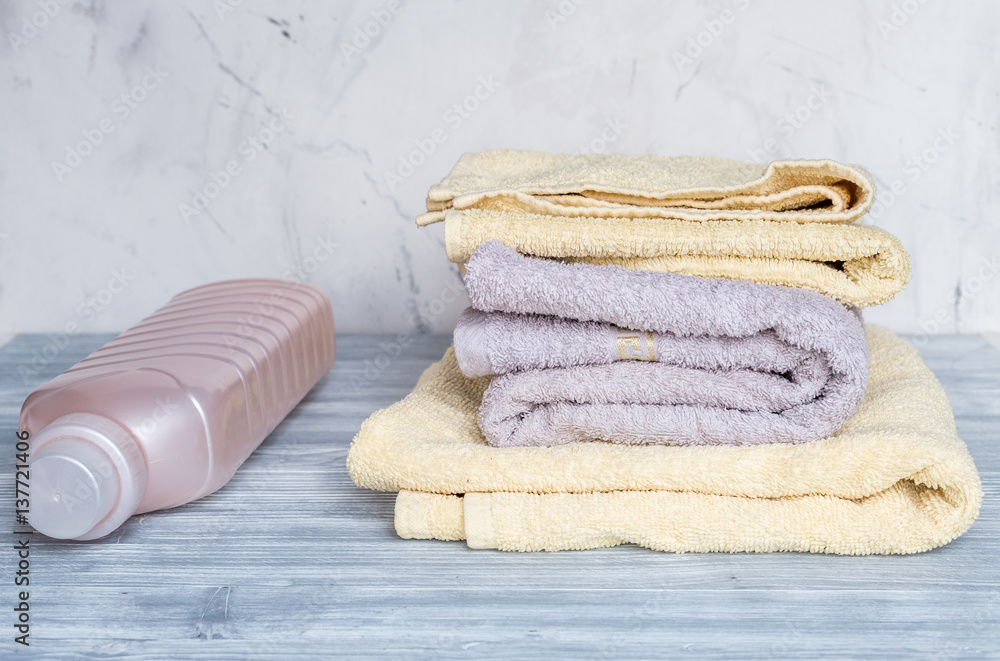 laundry set with towels and plastic bottels on gray background