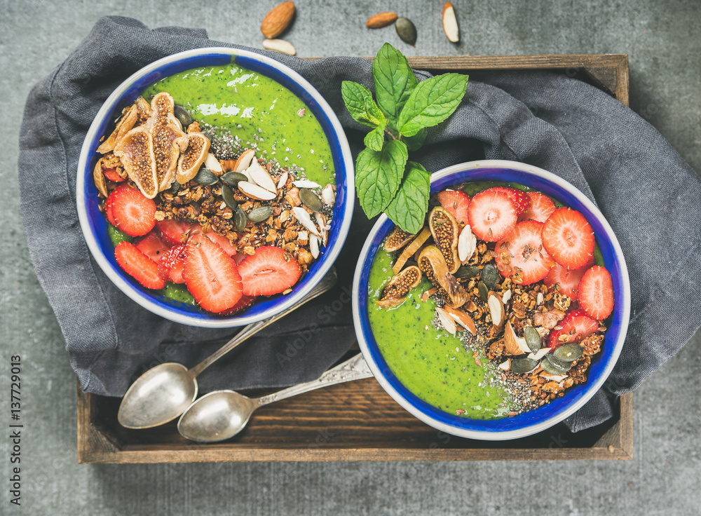 Healthy breakfast. Green smoothie bowls with strawberries, granola, chia and pumpkin seeds, dried fi