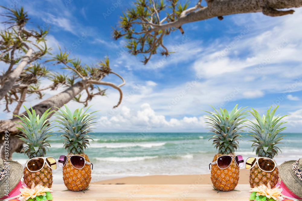 pineapple with sunglasses and hat beach on wood,concept summer background.