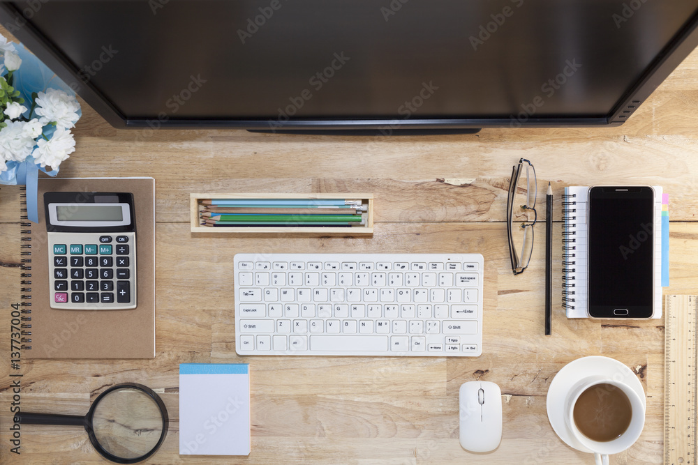 Top view with wood table, computer with keyboard,paper note,pencil,airplane model,flower,smartphone 