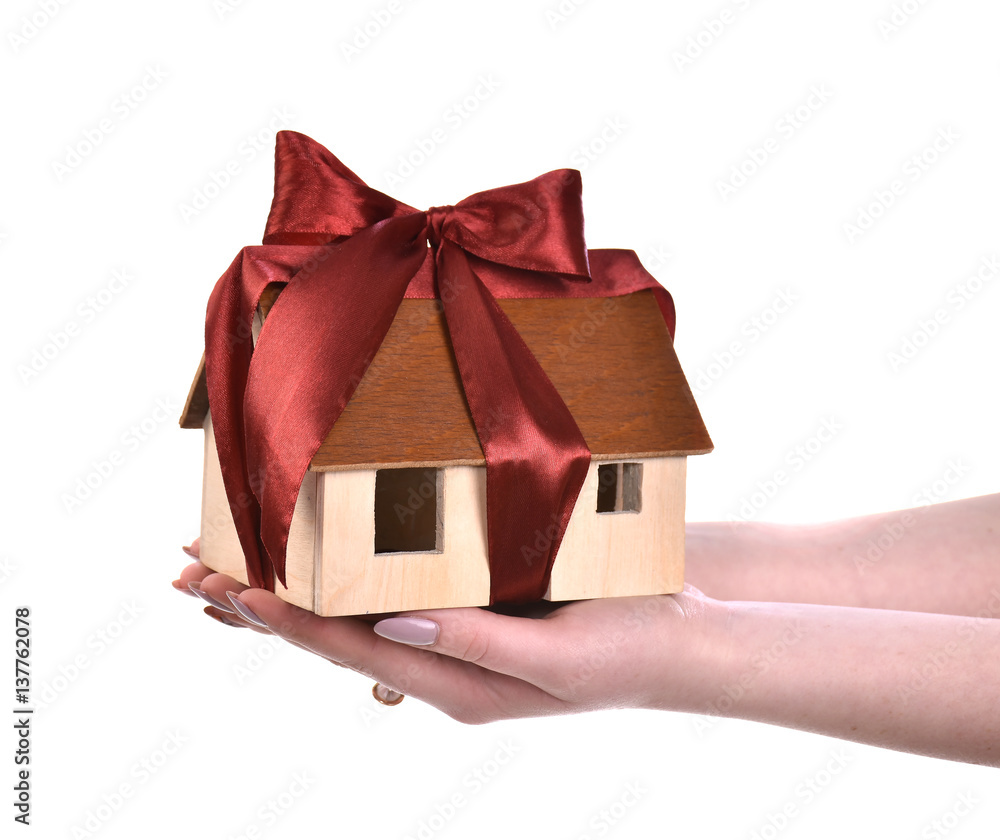 Image of woman hands holding wooden house