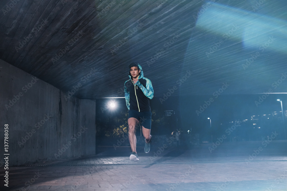 Young sportsman jogging in the night