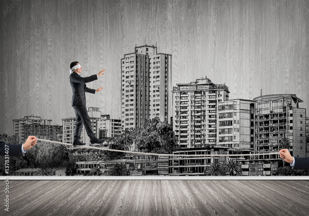 Business concept of risk support and assistance with man balancing on rope