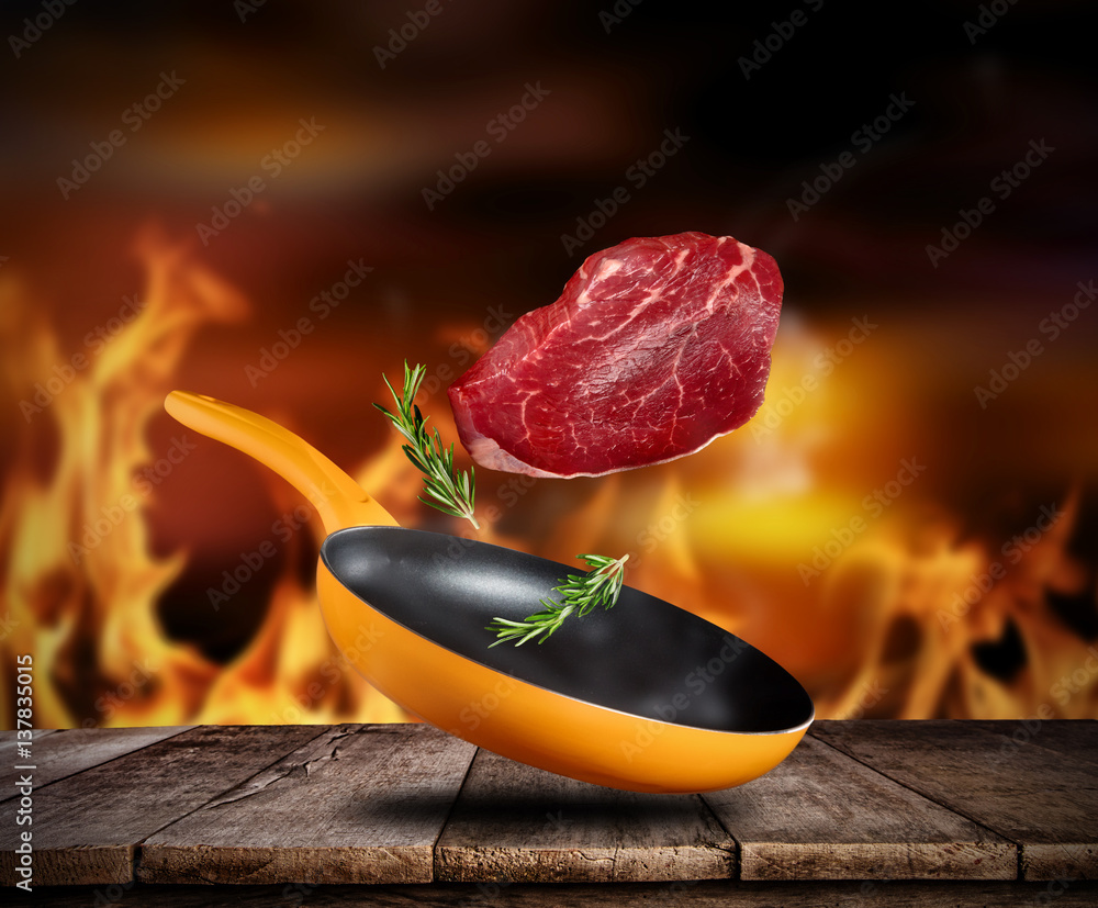 Fresh steak flying into a pan