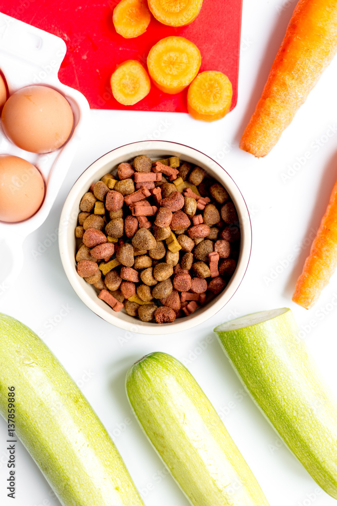 Set of animal dry food, vegetables and eggs on kitchen top view