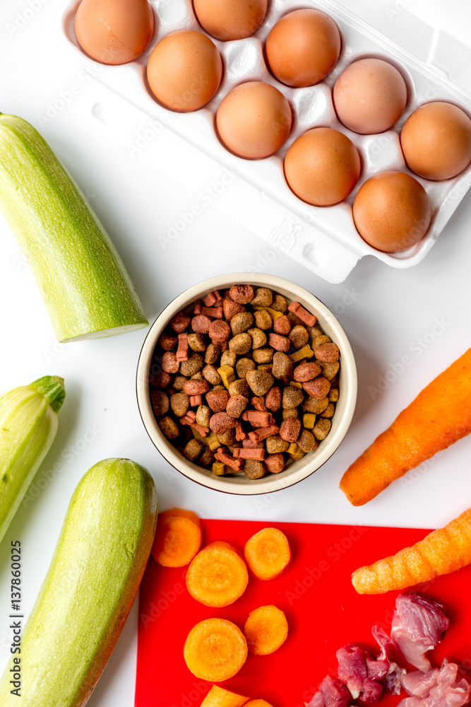 Dogfood set with vegetables, eggs and meat on table background top view