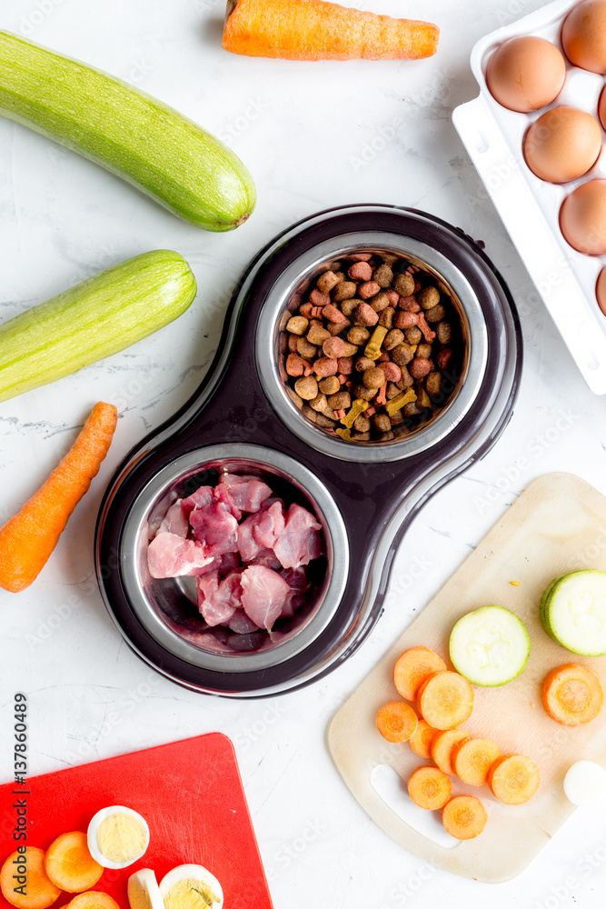 Dogfood, eggs, meat, carrot and courgette on table background top view