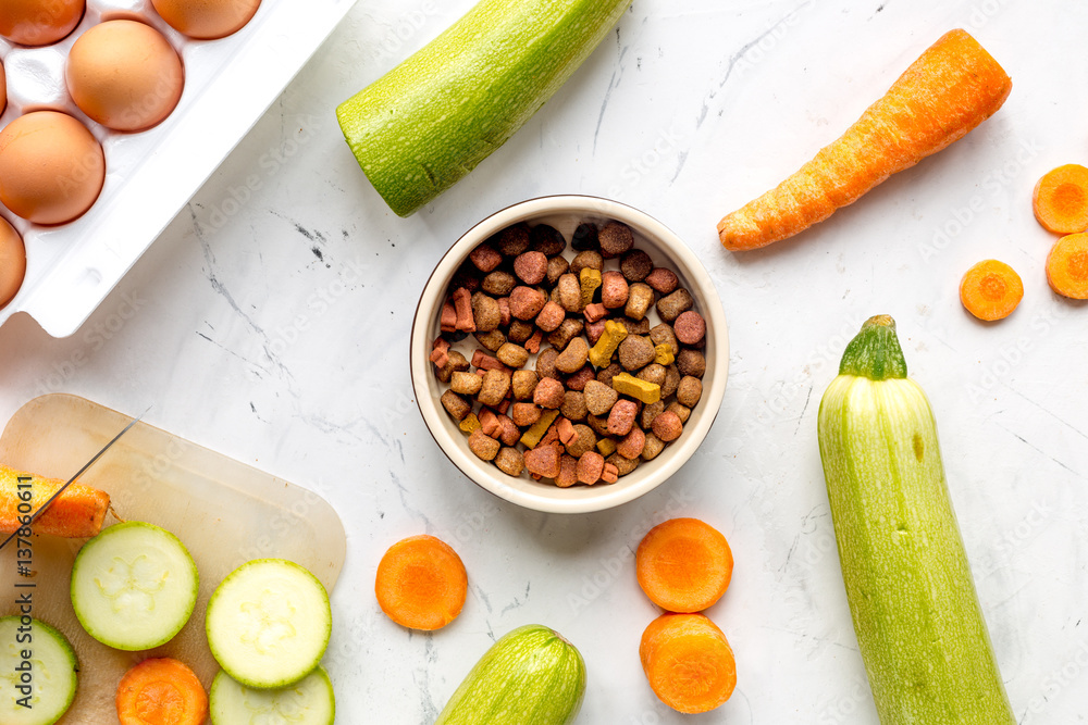 Vegetables and petfood on kitchen table background top view