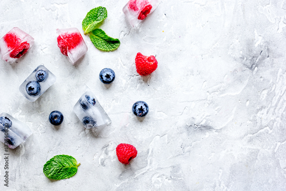 ice cubes with berries and mint on stone top view mock up