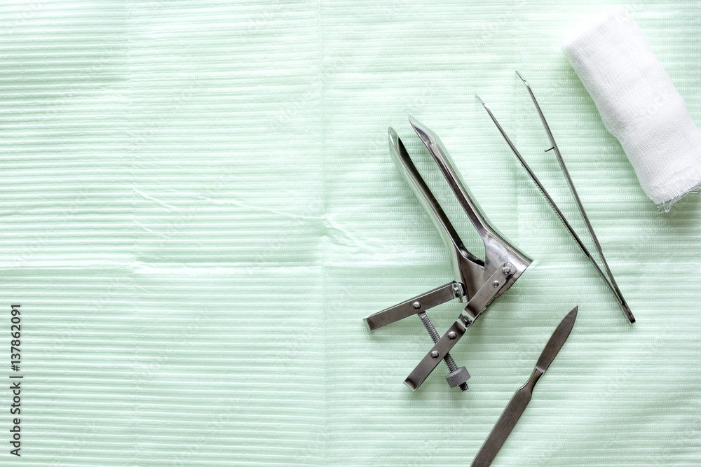 instruments of gynecologist on green background top view mock up