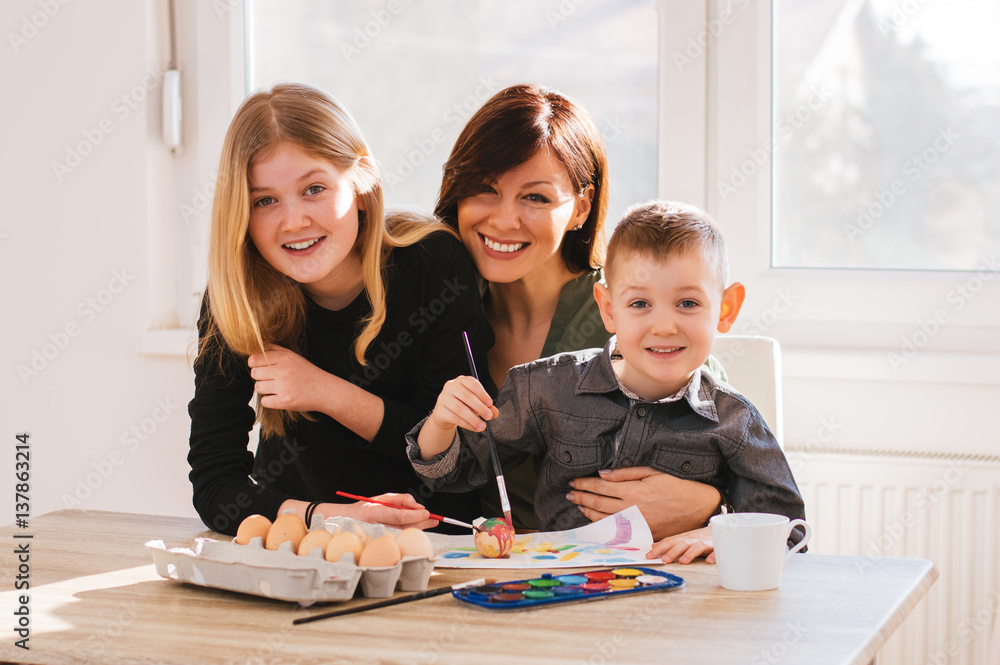 Mom painting with kids at home. Happy family time