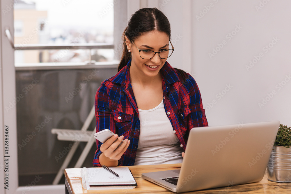 Charming European woman chatting in social network via laptop computer while sitting in modern inter