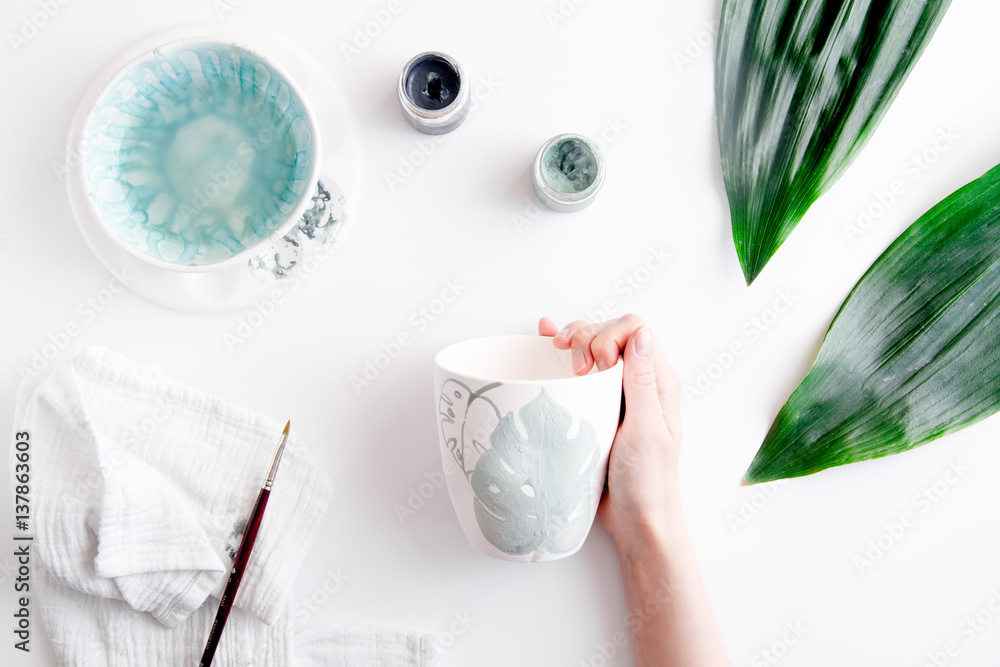 painted ceramic cup on white background top view