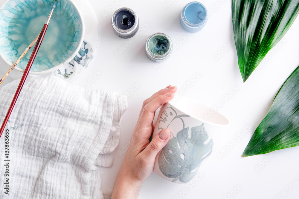 painted ceramic cup on white background top view