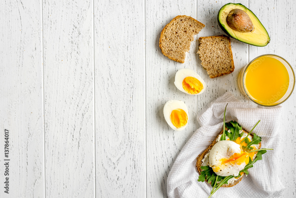 sandwich with poached eggs on wooden background top view mockup