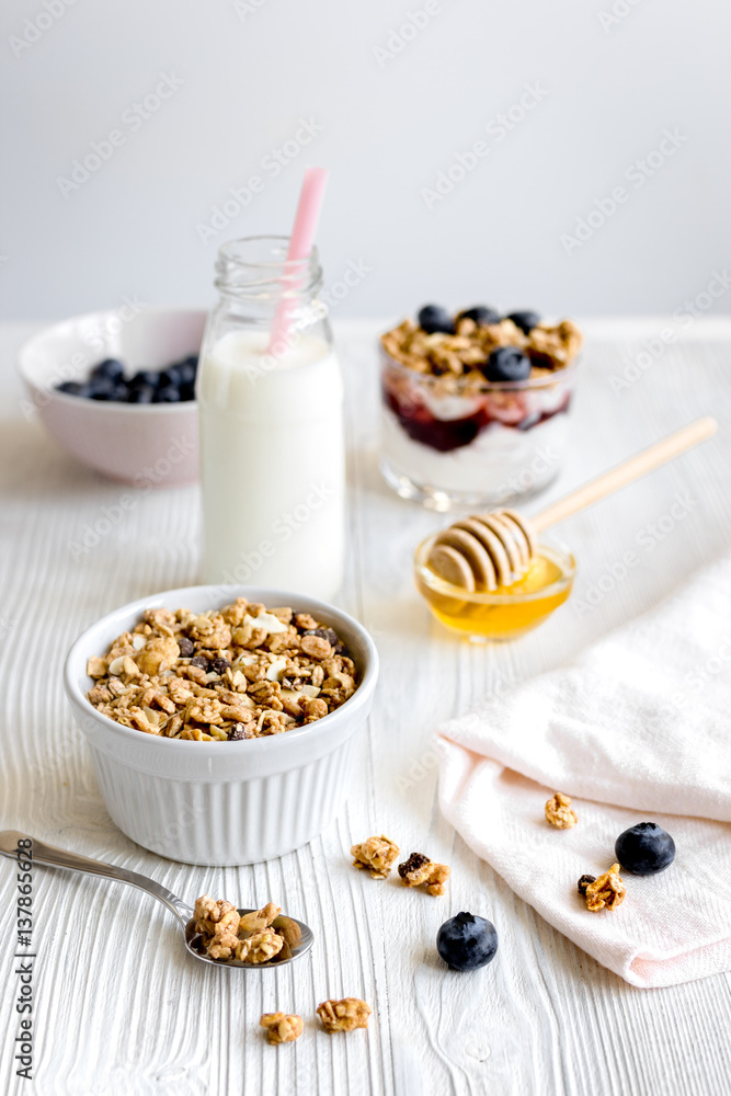 Cooking breakfast with granola and berries on white kitchen background