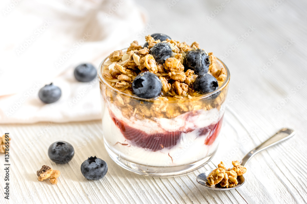 Morning granola with yogurt and berries on white kitchen background