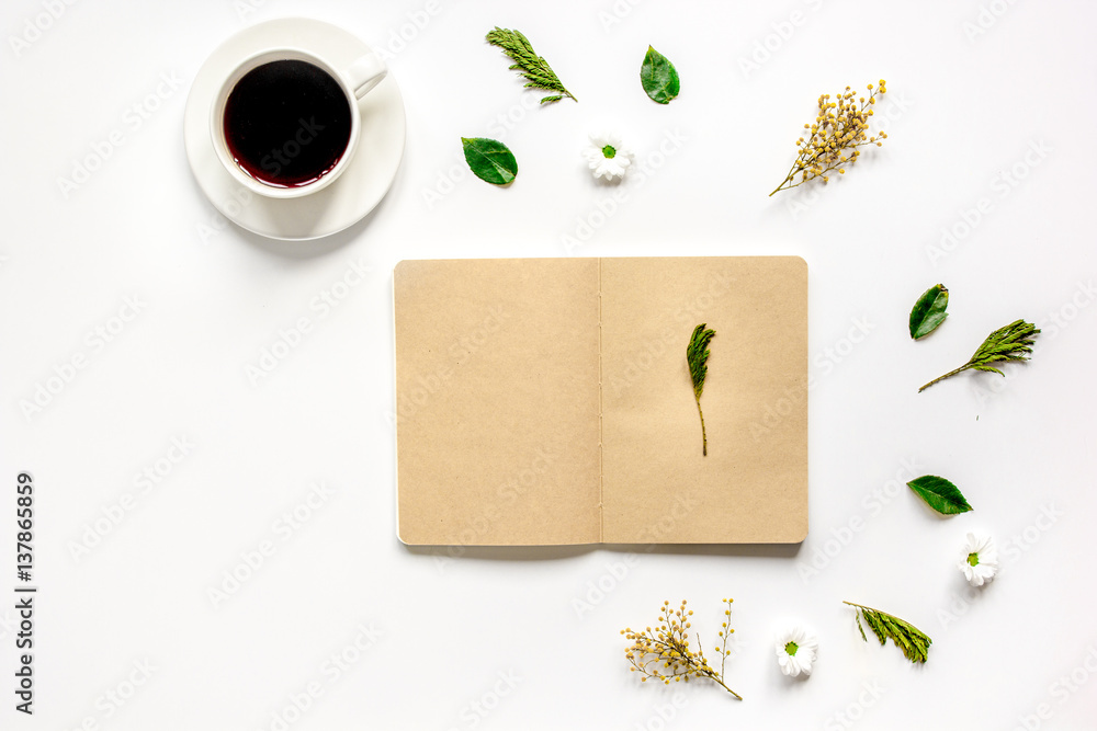 Petals, cup and copybook on table background top view mock up