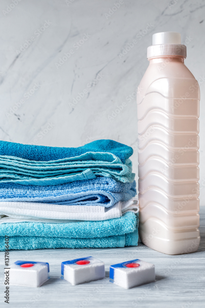 Towels pile with detergent and plastic bottles in laundry