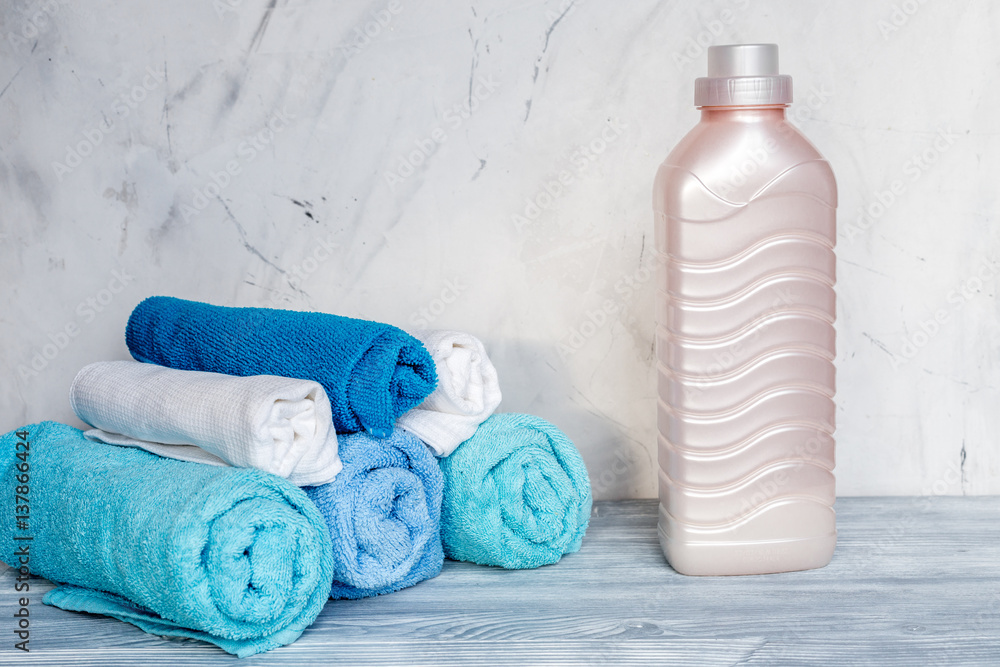 housekeeping set with towels and plastic bottles on laundry background mock up