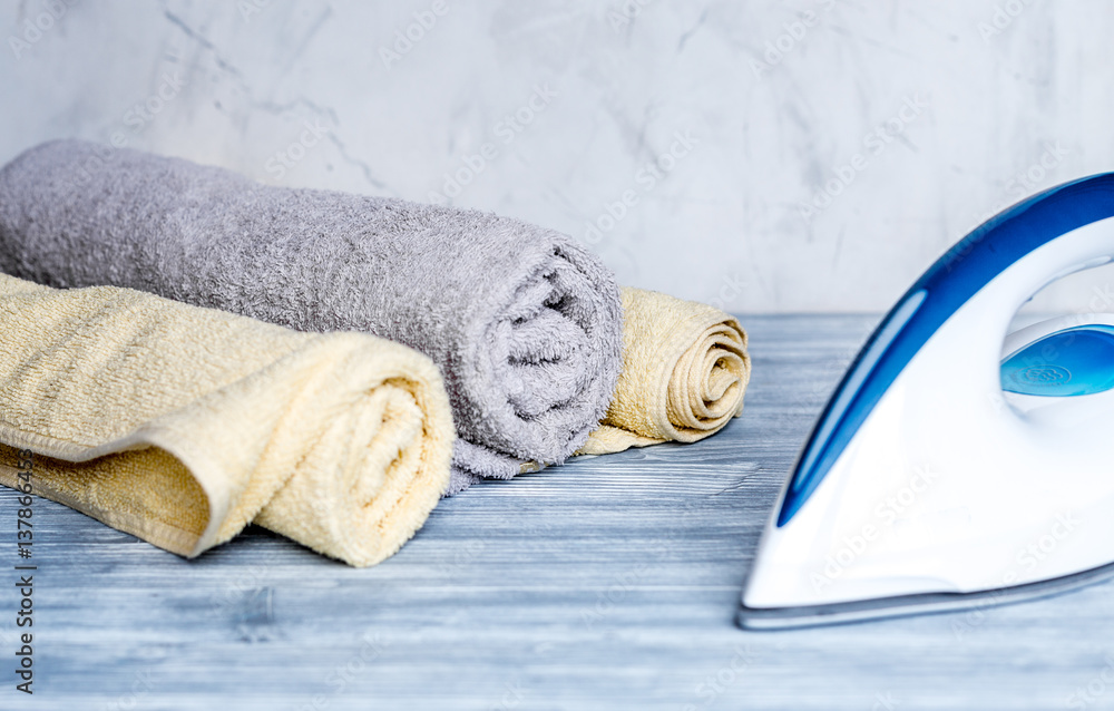 Launry set with towels and iron on gray background