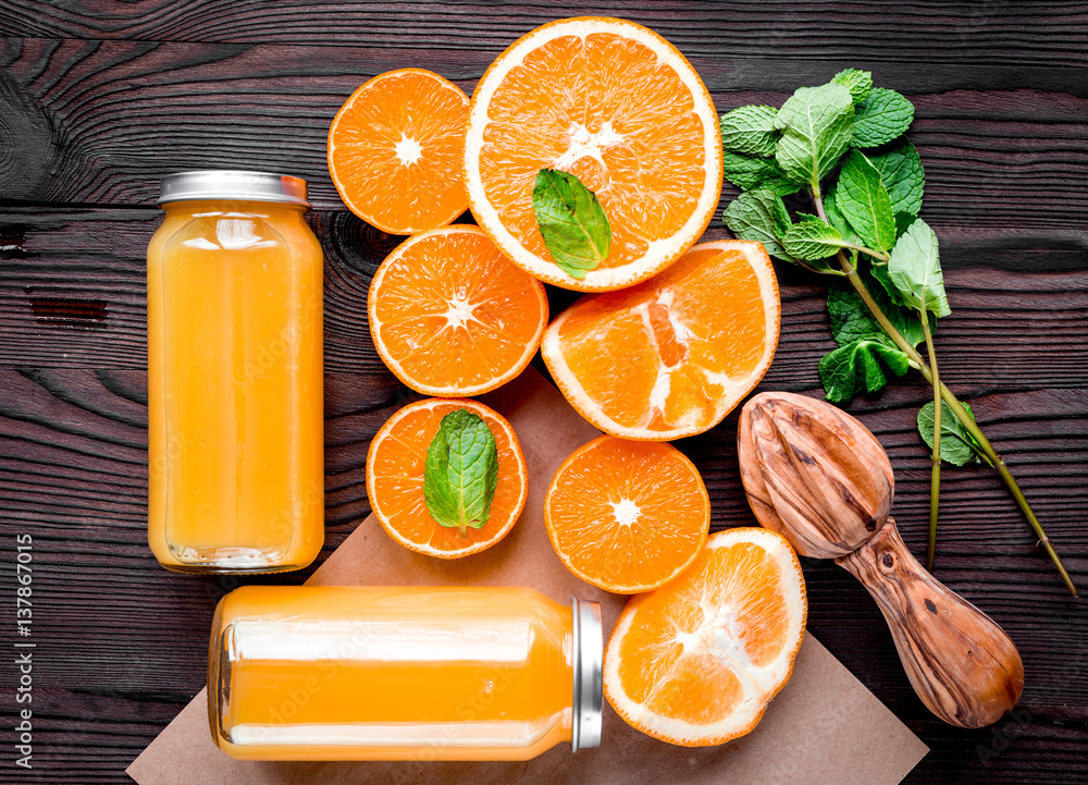 Homemade juice bottles with orange and mint on table top view