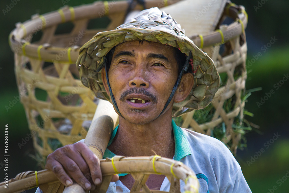 Balinese rice farmer with baskets.