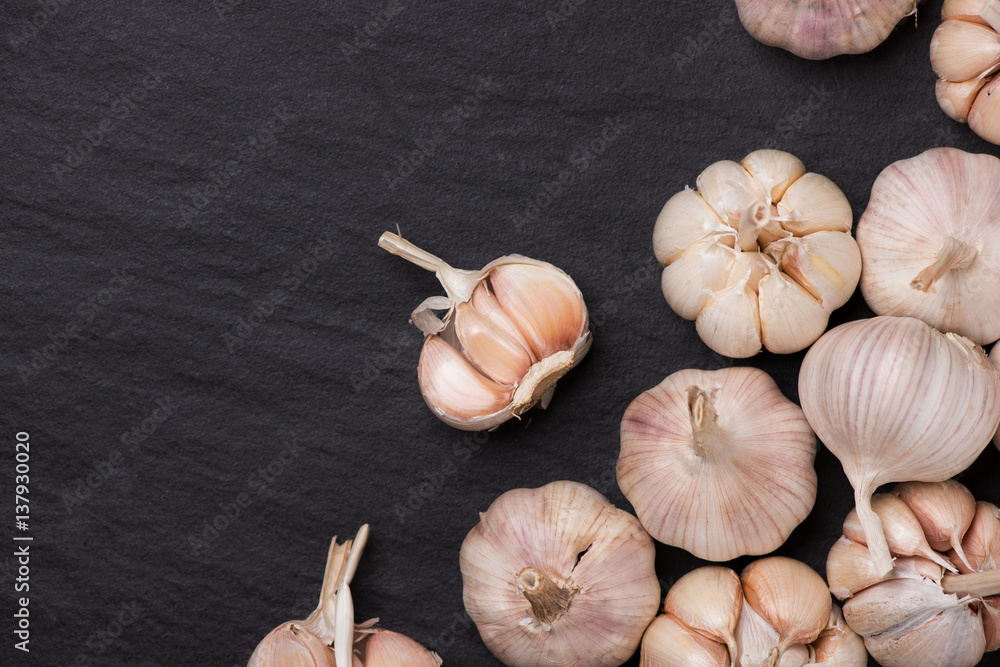 Garlic Cloves and Garlic Bulb on black stone table.