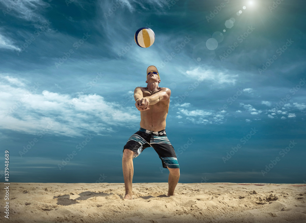 Beach volleyball player in action at sunny day under blue sky.