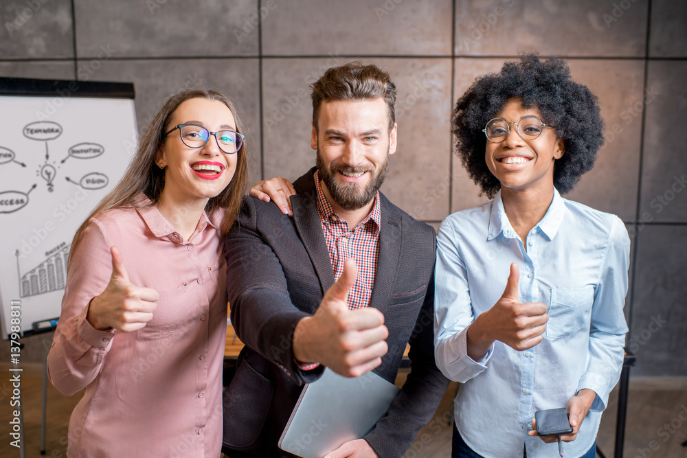 Portrait of three happy multi ethnic coworkers together at the office