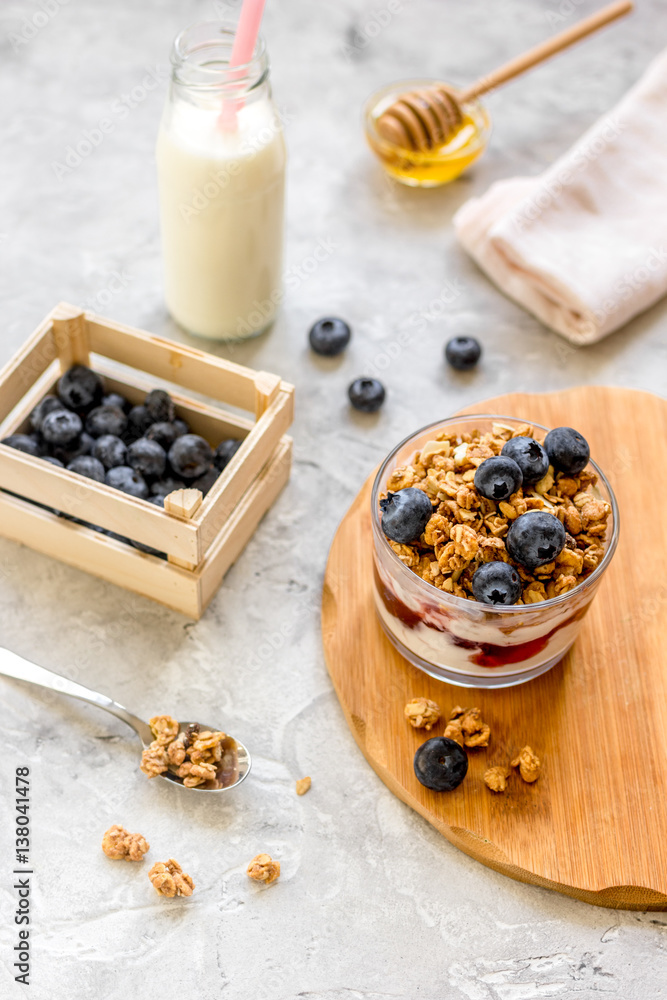 Morning granola with yogurt, honey and berries on white table