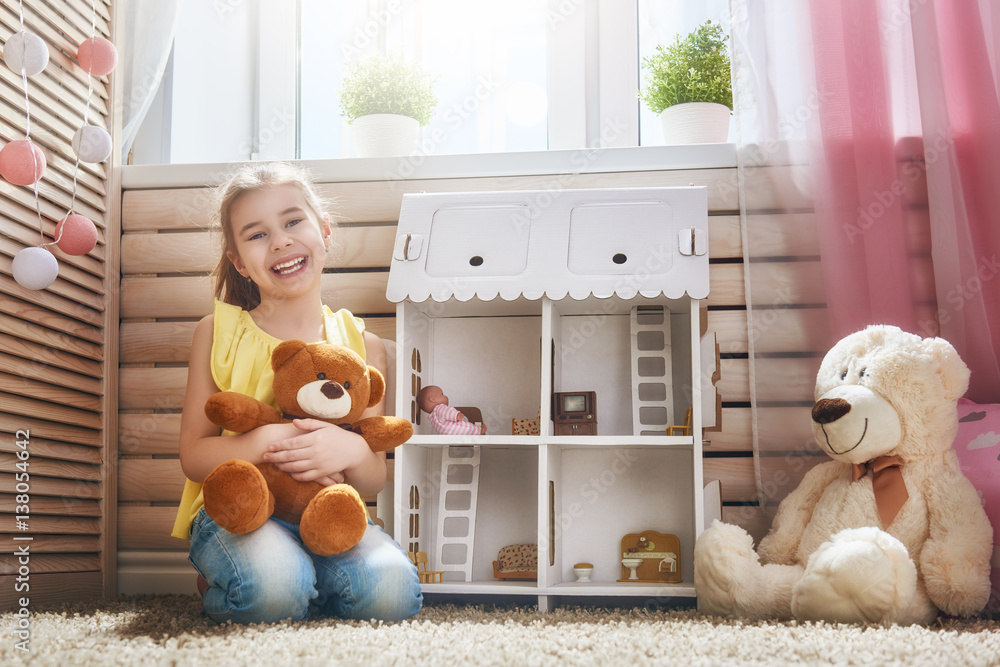 girl plays with doll house