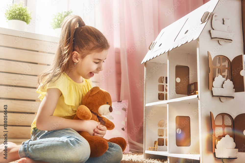 girl plays with doll house