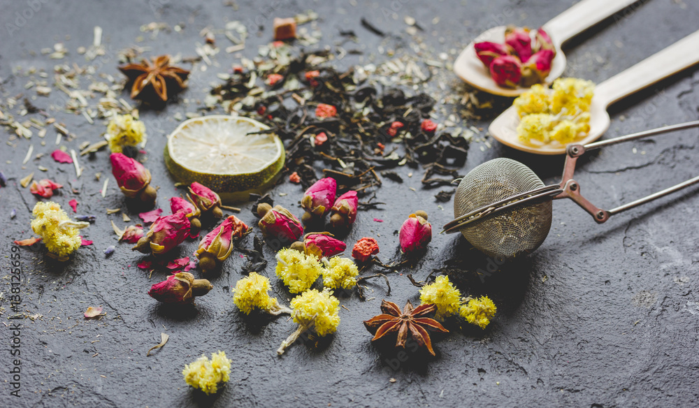 Spoons and herbs on grey background