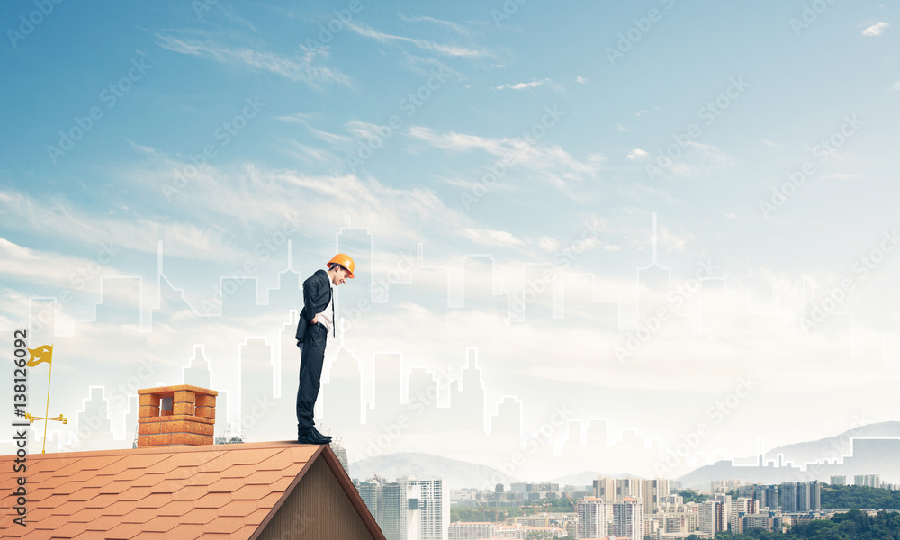 Engineer man standing on roof and looking down. Mixed media