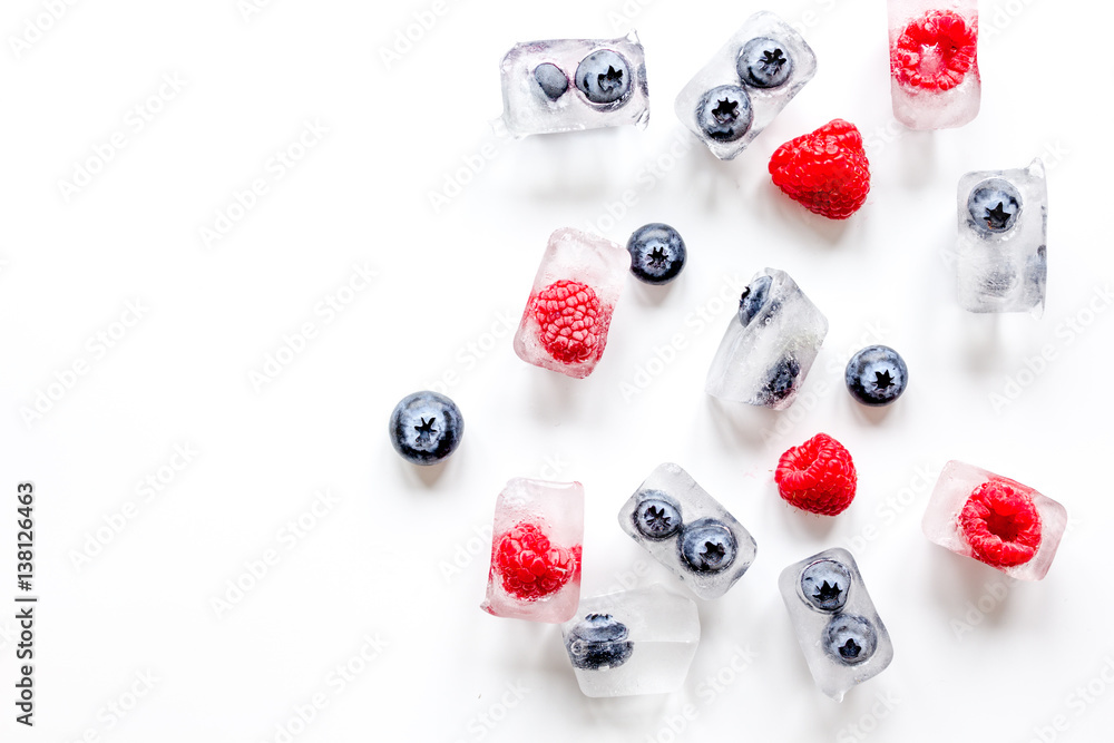 ice cubes with fresh berries on white background top view mock up