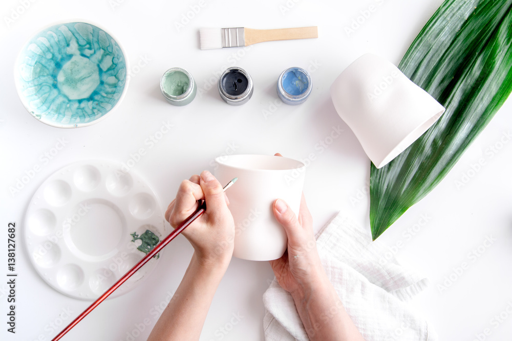 painted ceramic cup on white background top view